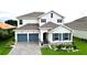 Two-story house with gray roof, blue shutters, and a stone facade at 30053 Island Club Dr, Tavares, FL 32778