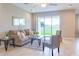 Living area with beige sofa, glass coffee table, and sliding doors to backyard at 30053 Island Club Dr, Tavares, FL 32778