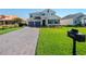 Two-story house with gray-toned garage doors and a brick driveway at 30053 Island Club Dr, Tavares, FL 32778