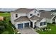 Two-story home with gray roof, blue doors, and stone accents at 30053 Island Club Dr, Tavares, FL 32778
