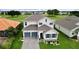 Two-story home with gray roof and blue garage doors at 30053 Island Club Dr, Tavares, FL 32778