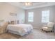 Spacious bedroom with a queen-size bed, nightstands, and an armchair at 30053 Island Club Dr, Tavares, FL 32778