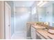 Spa-like bathroom with double vanity, large mirror, and a walk-in shower at 30053 Island Club Dr, Tavares, FL 32778