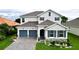 Two-story house with gray double doors and stone facade at 30053 Island Club Dr, Tavares, FL 32778