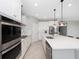 Open kitchen with white cabinets, stainless steel appliances & large island at 30053 Island Club Dr, Tavares, FL 32778