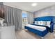 Bright bedroom with a blue upholstered bed and large window at 3954 Lana Ave, Davenport, FL 33897