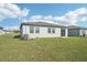 Home's backyard with grassy lawn and sliding glass door at 1705 Forest Run Ln, Auburndale, FL 33823