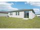 Home's backyard with grassy lawn and sliding glass door at 1705 Forest Run Ln, Auburndale, FL 33823