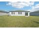 Home's backyard with grassy lawn and sliding glass door at 1705 Forest Run Ln, Auburndale, FL 33823