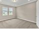 Spacious bedroom with neutral walls and carpet, featuring two windows with blinds at 3116 Legends Preserve Dr, Daytona Beach, FL 32124
