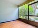 Empty screened porch with wood-look flooring and view of lush greenery at 3937 Atrium Dr # 5, Orlando, FL 32822