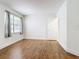 Bright bedroom with wood-look flooring, large window, and door to hallway at 3937 Atrium Dr # 5, Orlando, FL 32822