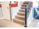 Indoor staircase with a black metal railing and gray carpeting at 4546 Narrative Ln, Kissimmee, FL 34746