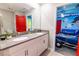 Bathroom with double vanity, grey countertop, and a view of a Toy Story-themed room at 4546 Narrative Ln, Kissimmee, FL 34746