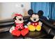 Large Mickey and Minnie Mouse plush toys on a black leather couch at 4546 Narrative Ln, Kissimmee, FL 34746