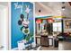 Bright living room featuring Mickey Mouse wall art, modern kitchen, and comfortable seating at 4546 Narrative Ln, Kissimmee, FL 34746