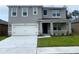 Two-story house with gray siding, white garage door, and landscaped lawn at 2530 Coachwood Dr, Ocoee, FL 34761