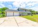 Two-car garage and house exterior with a large backyard at 3202 Misty Morn Ct, St Cloud, FL 34771