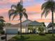 House exterior at sunset featuring a light blue accent and lush landscaping at 9226 Longfellow Pl, Apopka, FL 32703