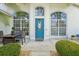 Inviting home exterior with a teal front door and landscaped entryway at 9226 Longfellow Pl, Apopka, FL 32703