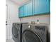 Laundry room with washer, dryer, and teal cabinets at 9226 Longfellow Pl, Apopka, FL 32703