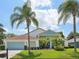 Single-story home with a light blue garage door and palm trees at 9226 Longfellow Pl, Apopka, FL 32703