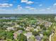 Aerial view of a neighborhood with houses, trees, and a lake in the background at 9226 Longfellow Pl, Apopka, FL 32703
