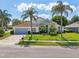 Charming one-story home with a light blue garage door and palm trees at 9226 Longfellow Pl, Apopka, FL 32703