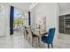 Elegant dining room with a glass-top table and blue velvet chairs at 9226 Longfellow Pl, Apopka, FL 32703