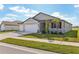 Two-car garage, light grey exterior, and a partially visible neighboring house at 2012 Rosewood Dr, Bartow, FL 33830