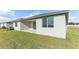 Back exterior view showing a patio and grassy yard at 2016 Rosewood Dr, Bartow, FL 33830