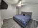 King bedroom with ceiling fan, wood-look floors, and mounted TV at 5434 River Rock Rd, Lakeland, FL 33809