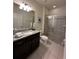 Bathroom with granite countertop, walk-in shower, and modern fixtures at 8940 Sydney Ave, Kissimmee, FL 34747