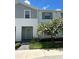 Two-story townhome with gray siding, green shutters, and landscaping at 8940 Sydney Ave, Kissimmee, FL 34747