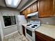 Efficient kitchen featuring wood cabinets and white appliances at 180 Waterfall Way # 203, Altamonte Springs, FL 32714