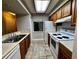 Galley kitchen with wood cabinets, white appliances, and tile floor at 180 Waterfall Way # 203, Altamonte Springs, FL 32714