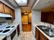 Galley kitchen with wood cabinets, white appliances, and tile floors at 180 Waterfall Way # 203, Altamonte Springs, FL 32714