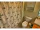 Tiled bathroom with a shower, toilet, and storage cabinet at 8516 Crystal Cove Loop, Kissimmee, FL 34747