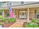 Brick home featuring a welcoming front porch with flag and flowers at 1709 Onondaga Dr, Geneva, FL 32732