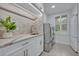 Laundry room with quartz countertop, sink and modern washer/dryer at 1709 Onondaga Dr, Geneva, FL 32732