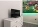 Bedroom with dresser, TV, and a window at 8951 Bismarck Palm Rd, Kissimmee, FL 34747