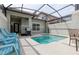 Private screened-in pool with multiple chairs and grill at 8951 Bismarck Palm Rd, Kissimmee, FL 34747