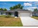 Gray house with a two-car garage and a stone accent wall at 43 S Kentucky Ave, Umatilla, FL 32784