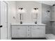 Double vanity bathroom with gray tile shower and white cabinets at 43 S Kentucky Ave, Umatilla, FL 32784