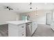 Modern kitchen island with white cabinets, quartz countertops, and stainless steel dishwasher at 43 S Kentucky Ave, Umatilla, FL 32784