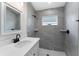 Bathroom with single vanity, gray tile shower, and white cabinets at 43 S Kentucky Ave, Umatilla, FL 32784