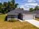 Single-story home with gray exterior, stone accents and a two-car garage at 43 S Kentucky Ave, Umatilla, FL 32784