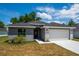 Newly built gray house with white garage door and stone accents at 43 S Kentucky Ave, Umatilla, FL 32784