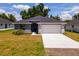 Charming one-story home with gray exterior and white garage door at 43 S Kentucky Ave, Umatilla, FL 32784
