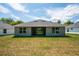 Gray house with a covered patio and spacious backyard at 43 S Kentucky Ave, Umatilla, FL 32784